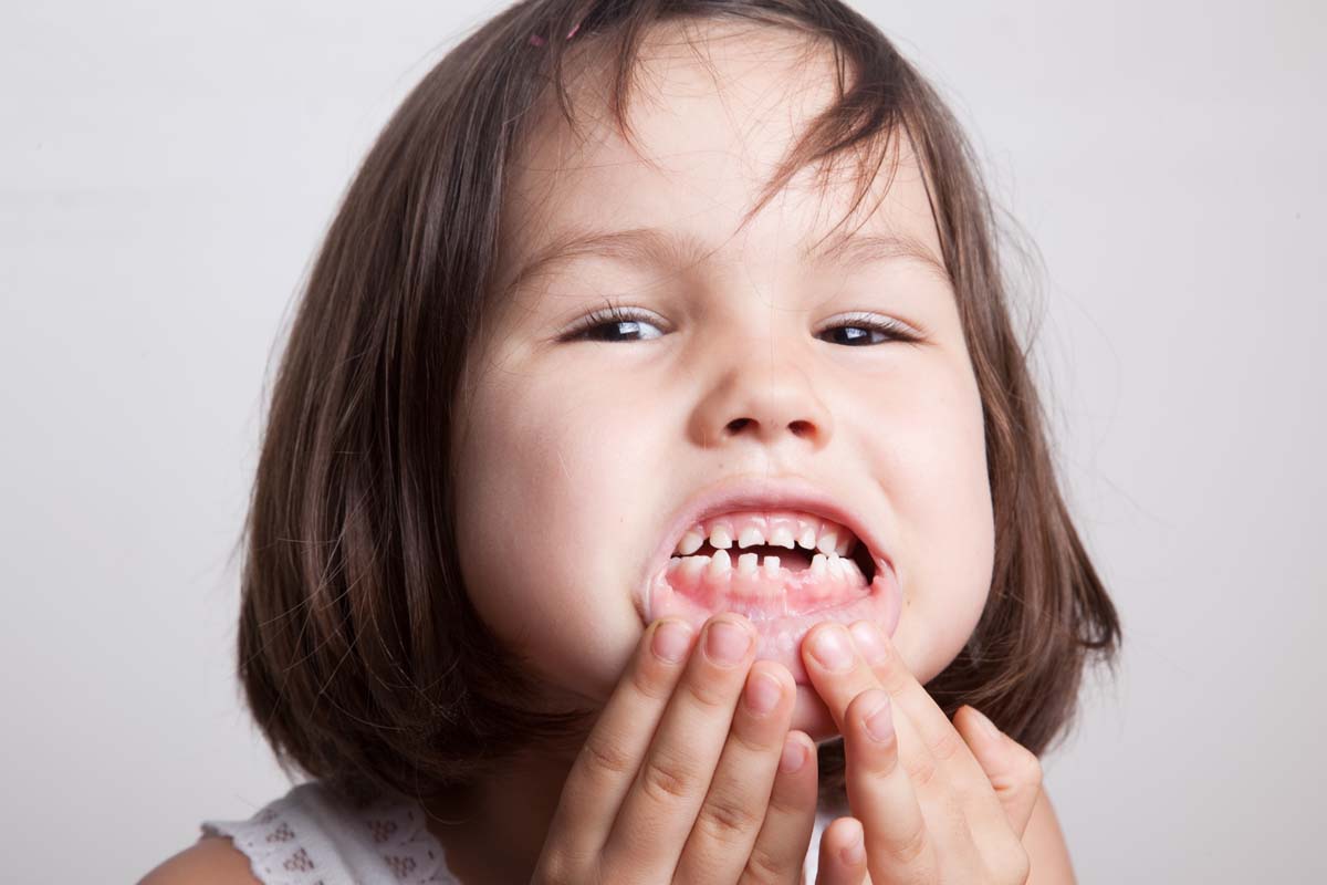 image of young child holding jaw teething pain